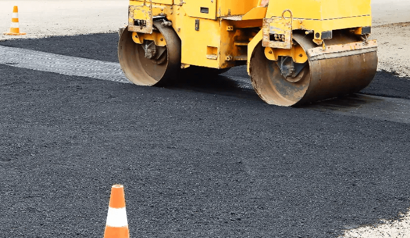 Asphalt paver smoothing out asphalt for parking lot.